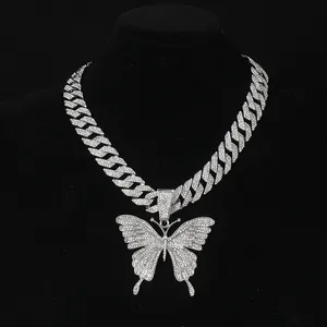 Detailed close-up of icy butterfly pendant with encrusted crystals on a Cuban link chain