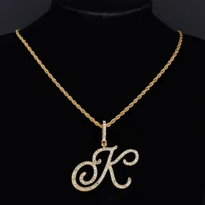 Détail du pendentif lettre K doré avec strass brillants sur une chaîne torsadée