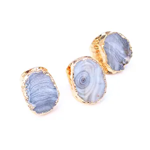 Detalle de tres anillos dorados ajustables con rodajas de ágata natural irregulares