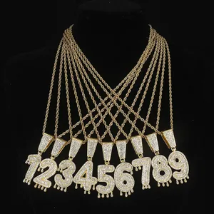 Dettaglio di ciondoli numerici in stile hip-hop con effetto goccia e strass incastonati