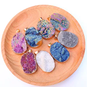 Natuurlijke druzy kristallen hangers met gouden rand in diverse kleuren op dienblad