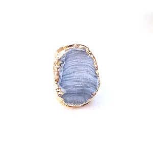 Detalle macro del anillo de piedra natural azul irregular con borde chapado en oro