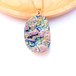 Detail van een vergulde regenboog druzy kwartskristallen hanger op hout achtergrond