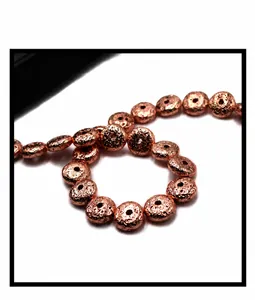 Macro detail of rose gold plated lava stone beads with textured disk surface for DIY jewelry