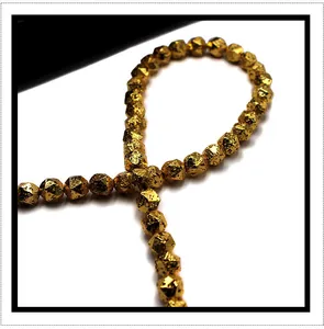 Macro shot of faceted gold volcanic stone beads for DIY jewelry with lava texture details