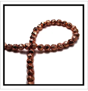 Macro view of faceted metallic rose gold beads made of natural volcanic stone