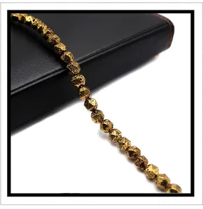 Macro detail of gold plated volcanic stone beads with diamond cut facets and lava textures