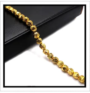 Detailed view of faceted gold-plated volcanic stone beads with metallic luster