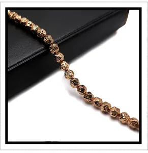 Macro shot of gold plated volcanic stone beads with textured diamond cut finish