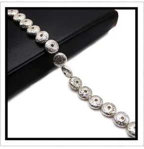 Macro detail of silver plated lava stone round beads with metallic crater texture for DIY