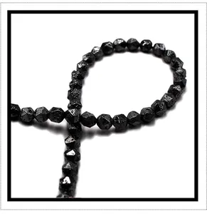 Detail view of faceted black volcanic stone beads with metallic luster for jewelry making