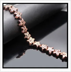 Vista macro di perle in pietra lavica a stella con placcatura metallica bronzo per DIY