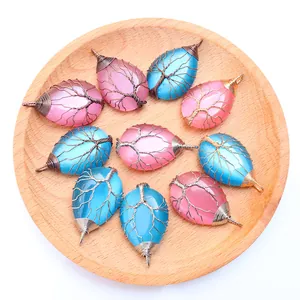 Detail von handgefertigten Lebensbaum-Anhängern in rosa und blauen Kristall-Wassertropfen
