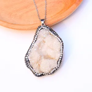 Vista detallada del colgante de cristal druzy con borde de diamantes en cadena de plata