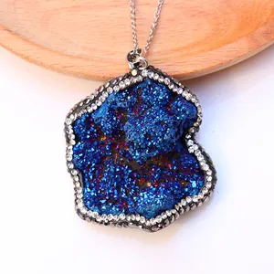 Primer plano de un colgante de piedra druzy azul irregular con brillantes pedrería