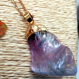 Détail macro du pendentif en cristal violet naturel avec enroulement de fil doré