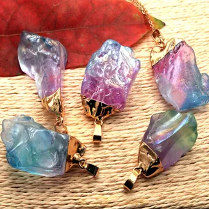 Détail de pendentifs en cristal coloré faits main avec fil doré et chaîne fine
