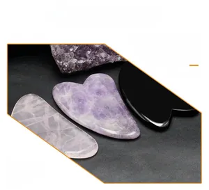 Makroaufnahme von Amethyst, Rosenquarz und Obsidian Gua Sha Schabern für die Gesichtsmassage
