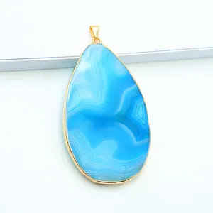 Detail van de blauwe druppelvormige agaat hanger met vergulde randen en natuurlijke textuur