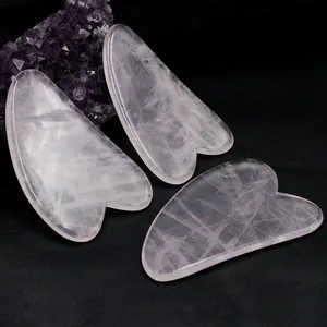 Natur Rosenquarz Gua Sha Gesichtsmassage Set dreiteilig auf schwarzem Hintergrund
