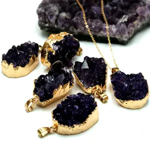 Macro detail van natuurlijke amethist hangers met goudvergulde messing randen op wit