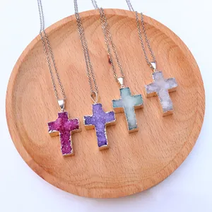 Makroansicht von Kristallkreuz-Anhängern mit Goldrand auf einem Holz-Display-Tablett