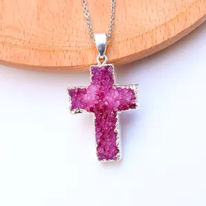Detailaufnahme von rosafarbenem Kristallkreuz-Anhänger mit silbernen Kanten