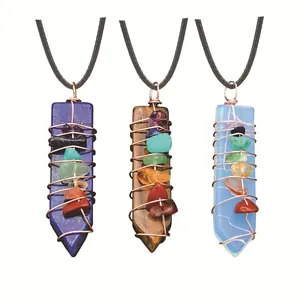 Natural crystal energy pendants with wire wrapping and chakra stones on white background