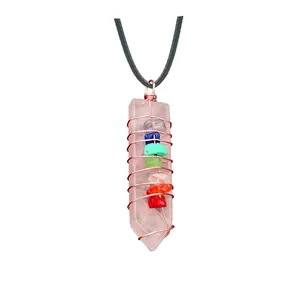 Macro shot of rose quartz pillar pendant wrapped in wire with seven chakra stones