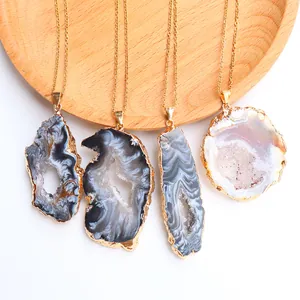 Dettaglio dei ciondoli a fette di geode di agata naturale con eleganti bordi placcati oro