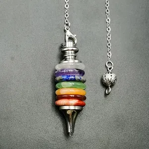 Macro shot of 7 chakra natural stones on a silver metal pendulum pendant with fine chains