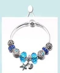 Détail du bracelet à breloques océan avec perles en verre bleues et pendentif étoile de mer