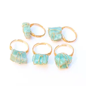 Detalle de cinco anillos hechos a mano con alambre de oro y cristales naturales azules