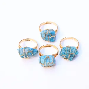 Vista detallada de cuatro anillos artesanales con piedras de apatita azul y alambre dorado
