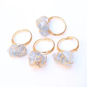 Detalle de anillos artesanales de hilo dorado con piedras naturales en azul claro
