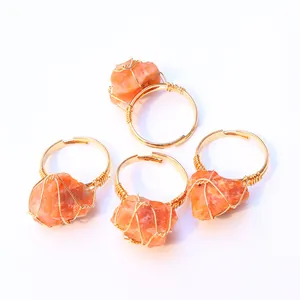 Detalle de cuatro anillos hechos a mano bañados en oro con piedras naturales naranjas
