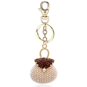 Golden handbag keychain with white pearls and sparkling red rhinestones for bag charm