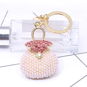 Luxury pearl handbag keychain with red rhinestones and golden alloy finish