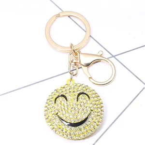 Close-up of a yellow rhinestone smiley face keychain with a golden lobster clasp