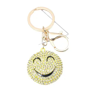 Sparkly yellow smiley face keychain with white rhinestones and gold-tone metal clasp