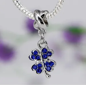 Gros plan du pendentif trèfle en argent avec cristaux bleu foncé sur chaîne serpent