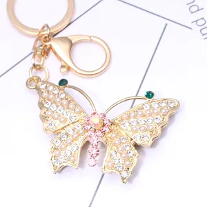 Golden butterfly keychain with inlaid pearls and crystals on a metal lobster clasp