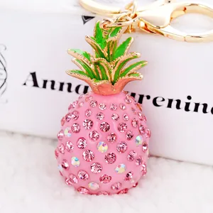 Macro detail of pink rhinestone pineapple keychain with golden lobster clasp and ring