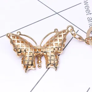 Golden butterfly keychain with rhinestone accents and clover cutout on back