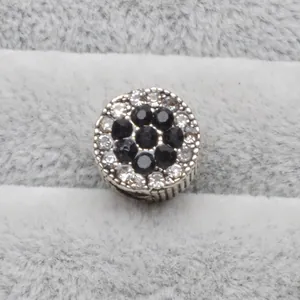 Gros plan d'une perle en argent sertie de pierres noires et cristaux blancs brillants