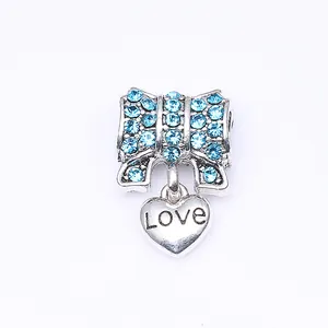 Pendentif nœud argenté aux cristaux bleus et cœur suspendu gravé du mot Love