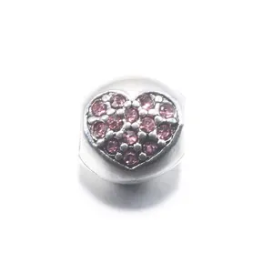 Κοντινό πλάνο με καρδιόσχημο DIY charm και ροζ ζιργκόν για βραχιόλια με χάντρες