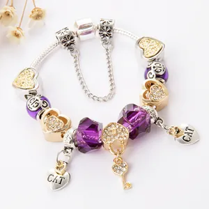 Goldenes Perlenarmband mit lila Kristallen, Herzschloss- und Schlüsselanhängern