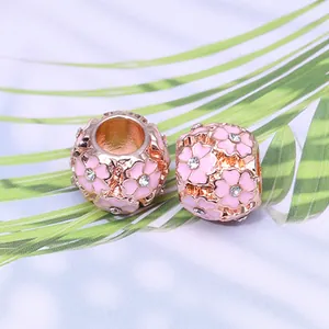 Détail macro de perles cerisier en or rose avec émail rose et cristaux pour bijoux DIY