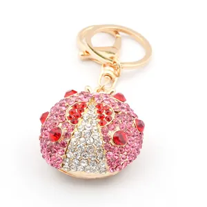 Détail du porte-clés coccinelle rose avec fermoir doré et strass brillants sur fond blanc